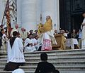 Cardinal Angelo Scola blessing the faithful with a monstrance and a golden humeral veil aorund his shoulders