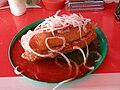 A torta ahogada or "drowned sub sandwich" covered in chile sauce