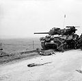 Troops take shelter near an M10 Wolverine tank destroyer - 6 June 1944