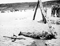 Crossed rifles in the sand are a comrade's tribute to this American soldier who sprang ashore from a landing barge and died at the barricades of Western Europe. 1944