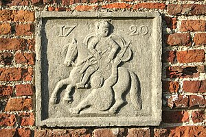 Façade stone dated and decorated with a low-relief showing Saint Martin and the beggar in Rebaix, Belgium