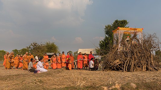 Buddhist monks procession in front of a pyre