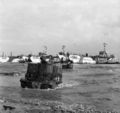 Universal carriers of 50th Division wade ashore from landing craft on Gold Beach, 6 June 1944