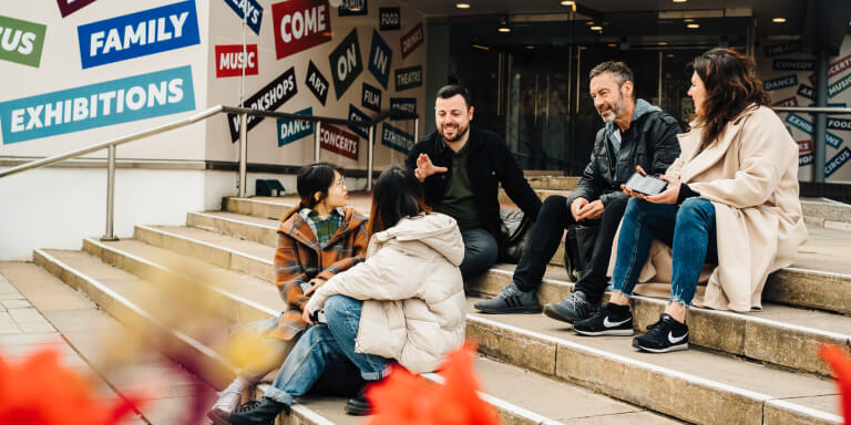 Staff in conversation on steps