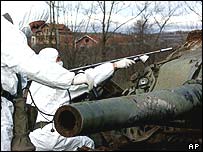 KFOR soldiers measure radiation levels near a Yugoslav tank destroyed during the  Nato bombing campaign in Kosovo