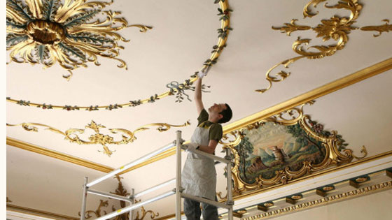Workman John Morisson cleans the ceiling in the main front hallway of Dumfries House, near Cumnock in Ayrshire