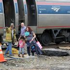 Einer Frau und einem Kind wird aus dem in Halifax verunglückten Zug geholfen am Montag, 9. März 2015.