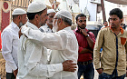 Relatives and local people mourn outside of a house in the Kasarvadavali area on the outskirt of Mumbai, India