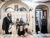 Yoelish Kraus with some of his 16 children at home in Jerusalem.  ‘He is like the king of the family,’ says his wife.