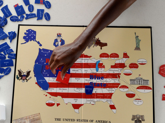 Sherri Pollard, places a game piece on the Red State Blue State political board game created by her 13-year-old son, Tyler Pollard from Ft. Collins. The game was created by Tyler at age six and teaches U.S. geography, American history and the electoral co