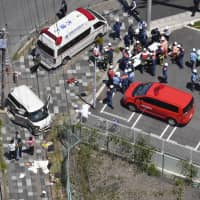 First responders tend to those injured in a car accident in Otsu, Shiga Prefecture, on Wednesday, in which a group of children were hit.