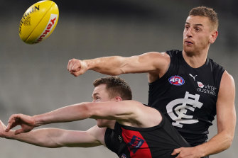 Pulling no punches: Carlton's Liam Jones clears ahead of Essendon's Jacob Townsend.