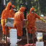 Workers in protective suits carry the coffin of a suspected victim of COVID-19 during a burial at Pondok Ranggon cemetery in Jakarta, Indonesia, earlier this month. 