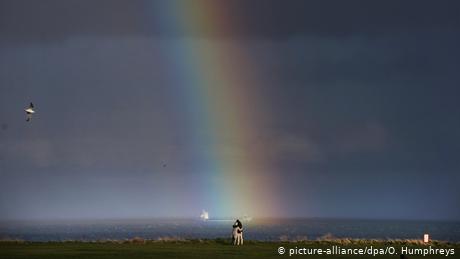 Mnogi novinari vole meteorološke metafore. Tmurno, kiša, i onda duga - i to u Velikoj Britaniji, koja se bliži Bregzitu. Svako bi mogao da interpretira to kako hoće, ali je istina da se fotograf Oven Hampris naprosto zatekao u pravom trenutku na pravom mjestu. Dvoje zagrljenih posmatraju horizont u Vajtli Beju, gradiću na Sjevernom moru nadomak Njukasla.