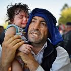  A man holds his crying child  at Tovarnik station, Croatia. Photograph:  Jeff J Mitchell/Getty Images
