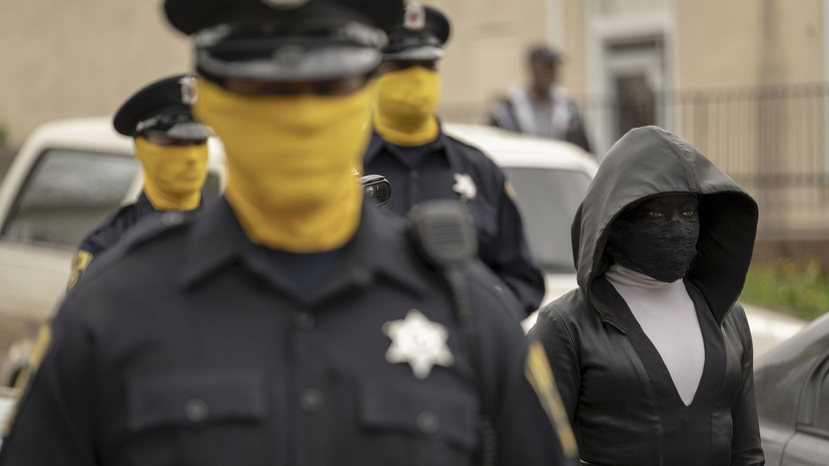 three cops with yellow masks accompany Sister Night on a sting