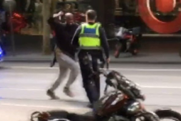 The Bourke Street attacker lunges with a knife at a police officer on Bourke Street.