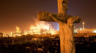 A graveyard in Louisiana with a chemical plant on the horizon (Credit: Alamy)