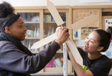 Two high school students work on science project designing wind turbine