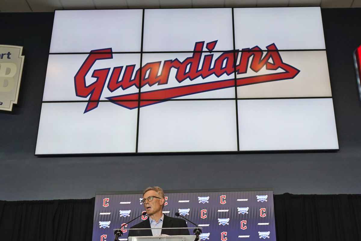 The word “Guardians” appears on a large screen behind a person standing at a lectern.