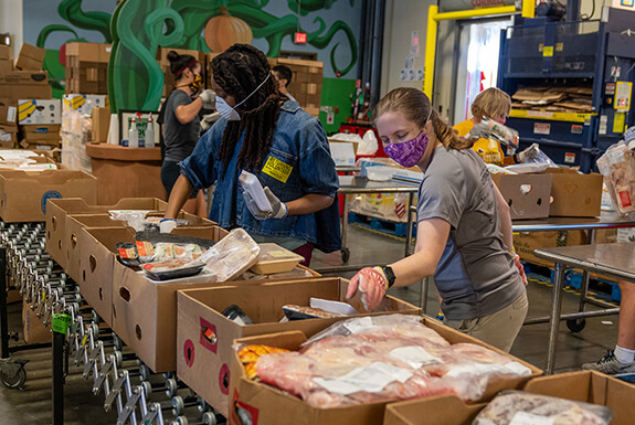 Employees filling boxes with food