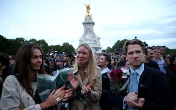 People react to the news of the Queen's death outside Buckingham Palace on Thursday evening