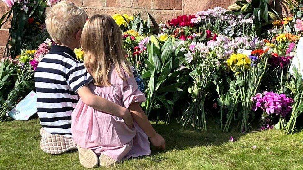 Children lay flowers at Hillsborough Castle