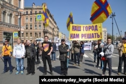 People march carrying the flag of Ingria in St. Petersburg on May 1, 2019.