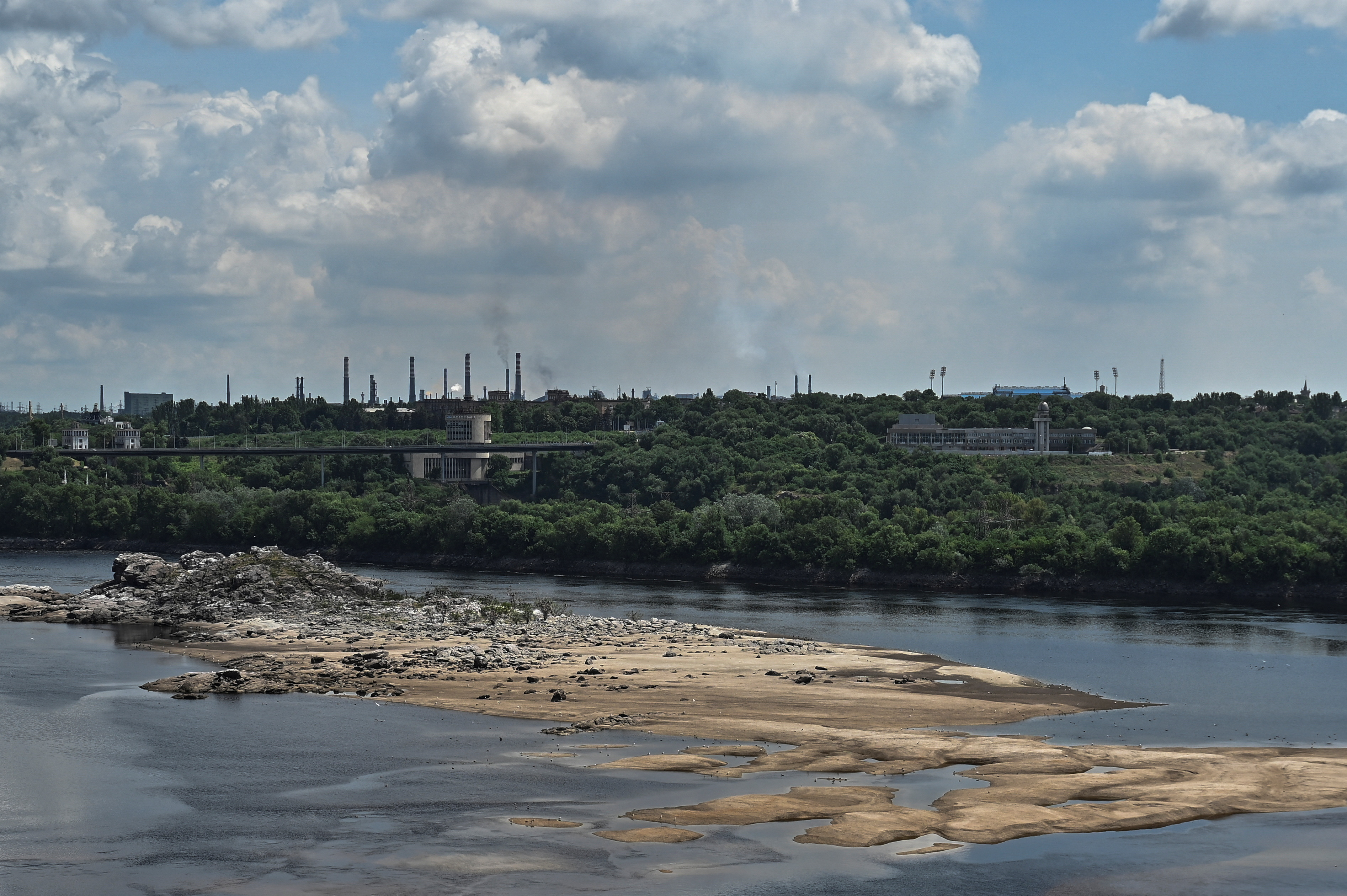 View shows the city skyline and a rocky island in the Dnipro river which became visible again after water level sharply dropped following Kakhovka dam destruction, in Zaporizhzhia