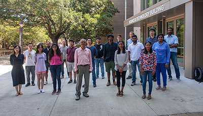 Faculty and students standing in front of the Artificial Intelligence building.