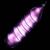 Glass tube shining violet light with a wire wound over it