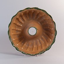 deep, ring-shaped pan showing decorative indentations