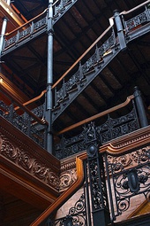 A photograph of a building interior showing stairs climbing up five storeys to the final floor where we can see the glass roof