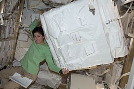 NASA astronaut Nicole Stott moving a stowage container inside HTV-1.