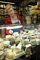 A counter sales assistant in a delicatessen offers taste tests and provides expert advice on products and uses