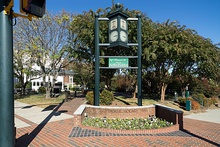 A clock in a small public square with a sign proclaiming it the hometown of Kellie Pickler