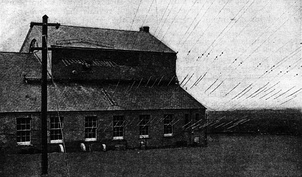 Transmitter building, showing the 36 feedlines feeding power to the 3,600 ft. flattop wire antenna.