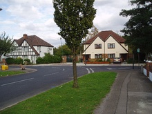 A row of suburban houses with white gabled ends and black timber beams