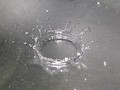A drop of water hitting a metal surface and crown formation due to splashing of droplet