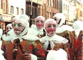 The Gilles, clad in their costumes and wax masks, wielding sticks used to ward off spirits