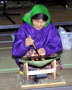 An Inuk woman tending a qulliq, a traditional whale, or seal, oil lamp (Nunavut, Canada, 1999)