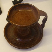 Whale oil lamp in brown-glazed earthenware with candle bowl for the wick and base drip pan. Lyse parish, Bohuslän – now in the Nordic Museum, Stockholm, Sweden