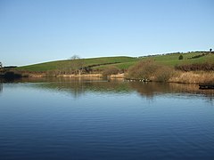 A small body of water with some low hills beyond