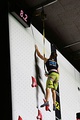 Hitting a button at the top of the wall stops the timer. The climber is secured by an auto-belay device.