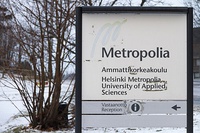 Side of a sign of the University of Applied Sciences oriented towards the southeast where direct sunlight impacting from dawn to afternoon has bleached the red and yellow colors from the logo of the institution.