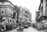 (Arriba) Hitler proclama el Anschluss en la Heldenplatz, Viena, el 15 de marzo de 1938. (Abajo) Los alemanes étnicos usan el saludo nazi para saludar a los soldados alemanes cuando entran en Saaz, 1938.