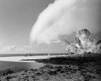 Detonation of the 500-ton TNT explosive charge as part of Operation Sailor Hat in 1965. The passing blast-wave left a white water surface behind and a white condensation cloud is visible overhead.