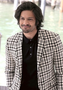 Ali Fazal looking away from camera