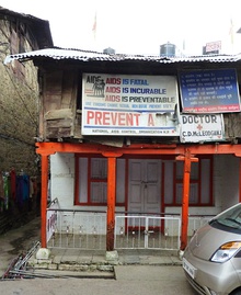 A run down a two-story building with several signs related to AIDS prevention