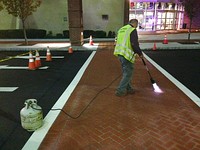 Polymer cement overlaying to change asphalt pavement to brick texture and color to create decorative crosswalk